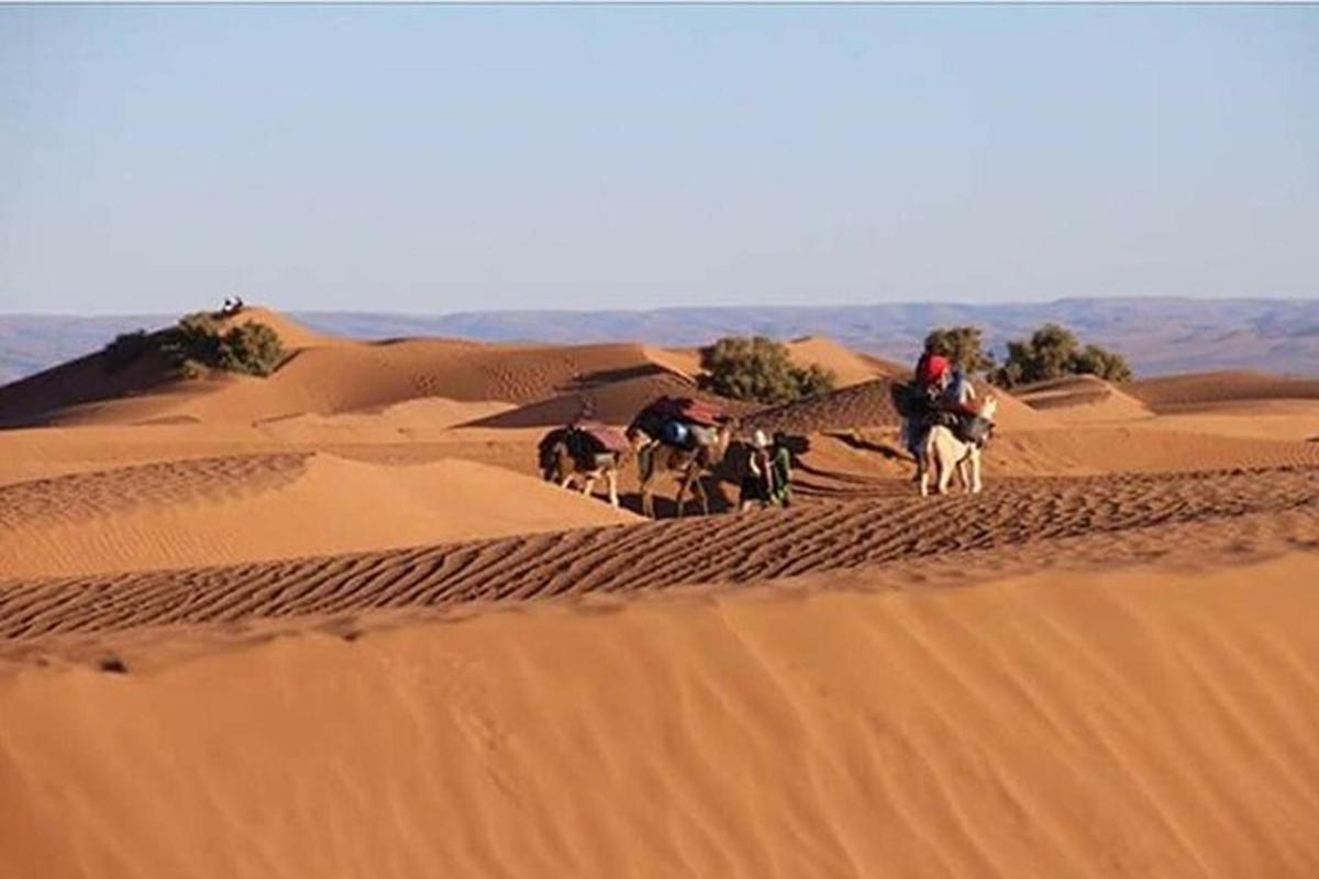 a group of people riding horses in the desert