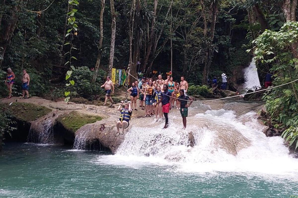 Un grupo de personas en un puente de cuerda sobre una cascada.