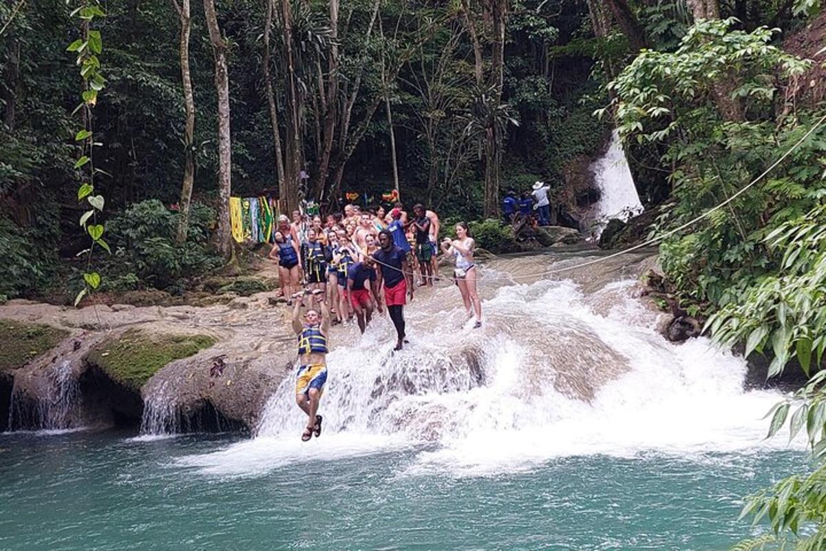 Un grupo de personas cruzando una cascada en un río.