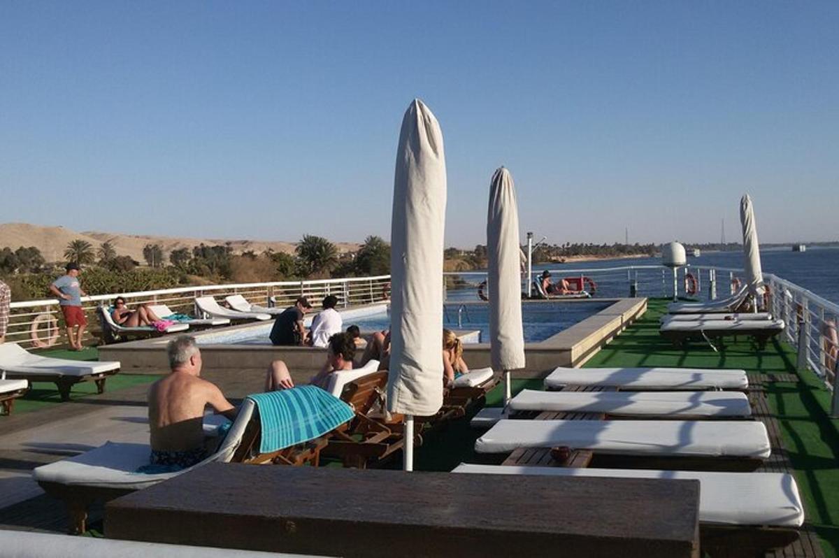 skupina ľudí sediacich na ležadlách pri vode