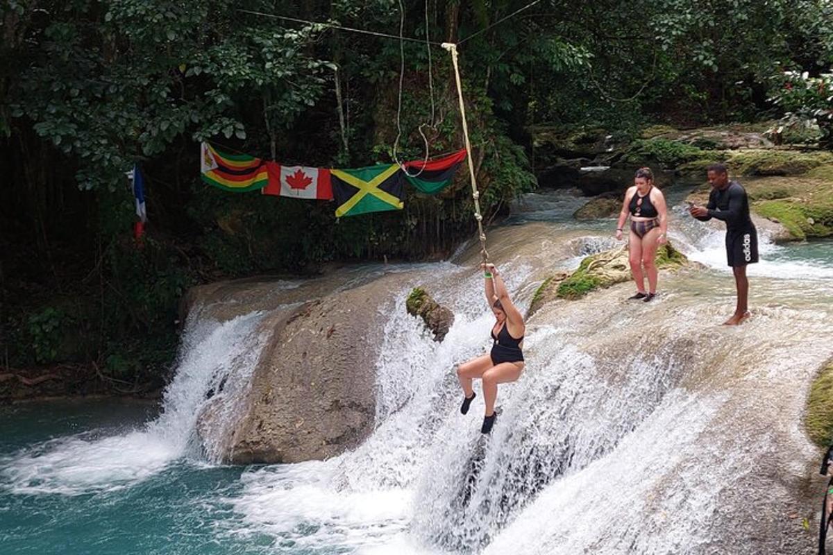 Una mujer está colgada de una cuerda en una cascada.