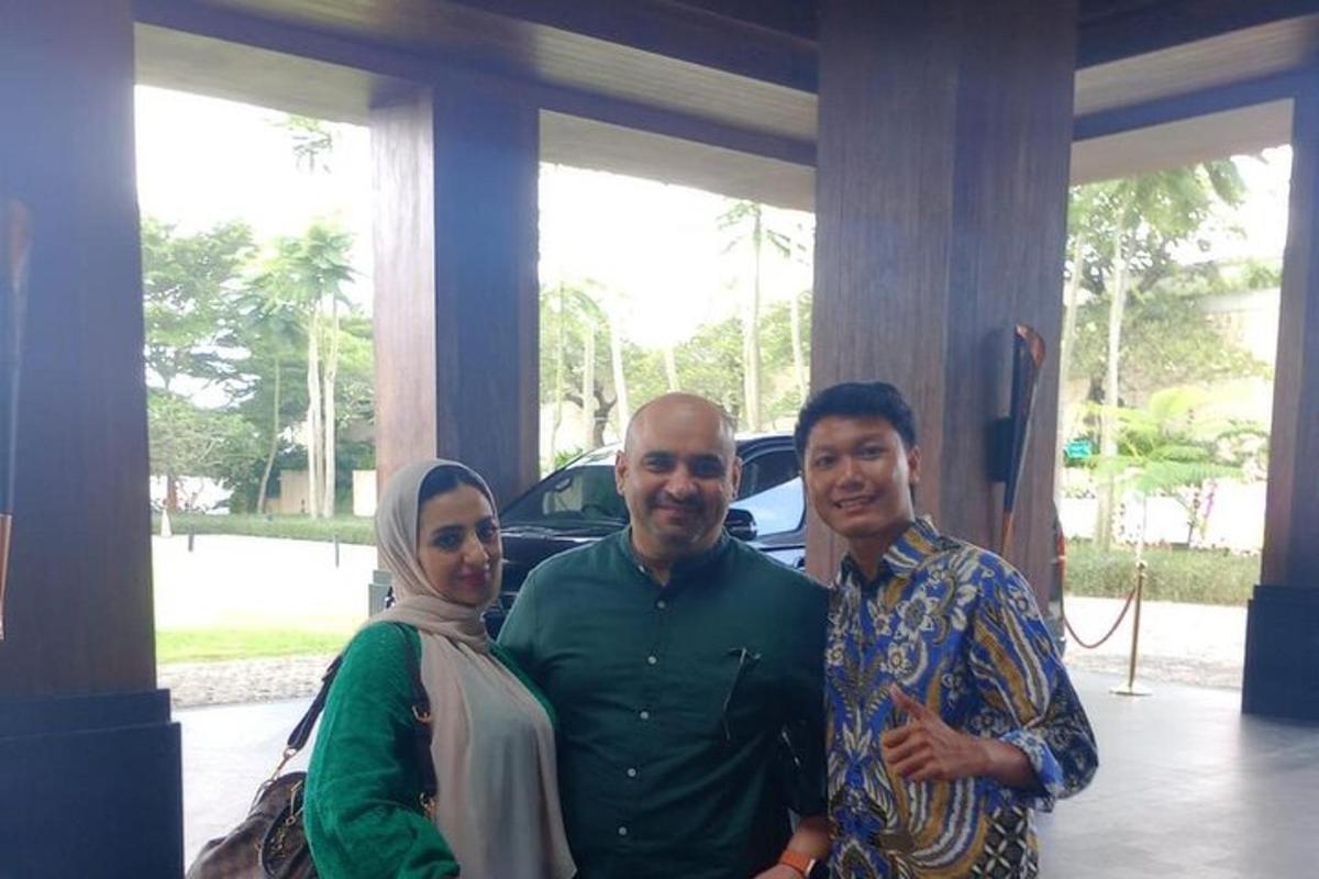 sekumpulan tiga orang berdiri di hadapan sebuah kereta