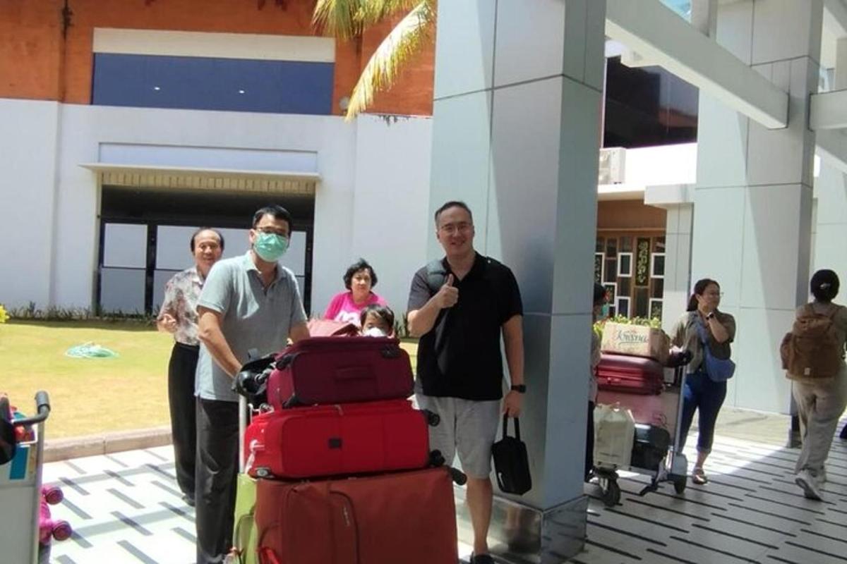 sekumpulan orang dengan bagasi di lapangan terbang