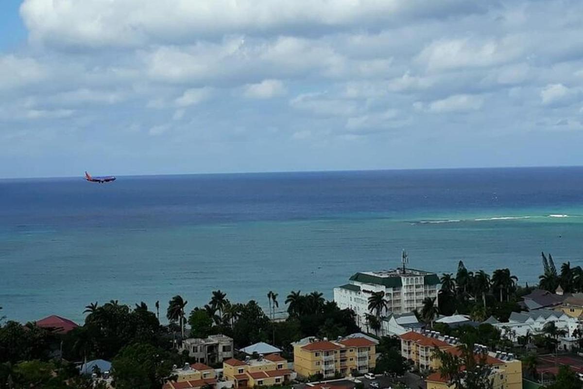 Letadlo letící nad oceánem s domy a budovami