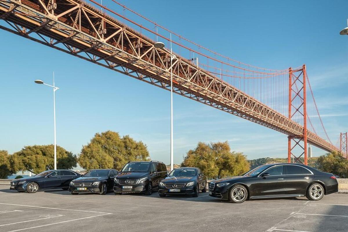 a group of cars parked in a parking lot under a bridge