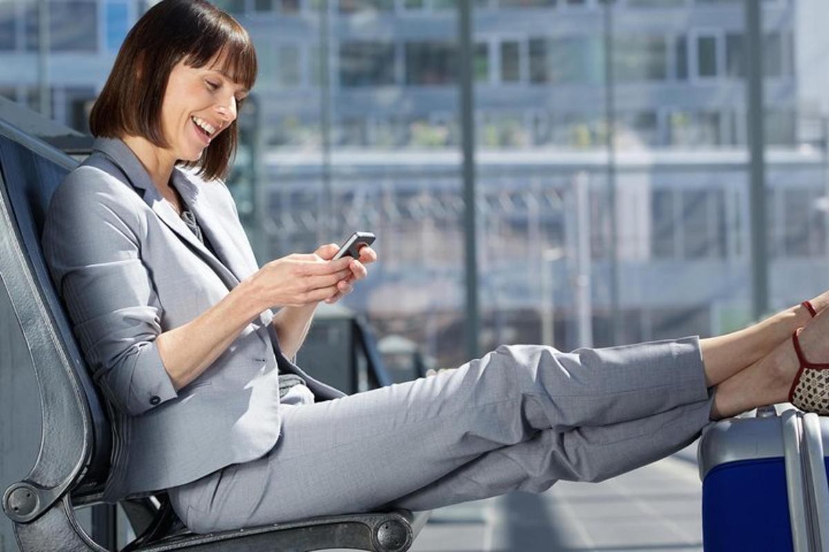žena sedící na židli a dívající se do svého mobilního telefonu