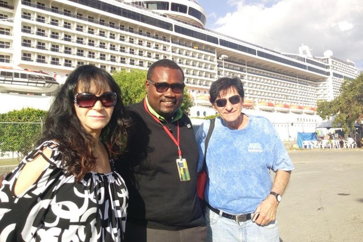 Un grupo de tres personas de pie frente a un crucero.