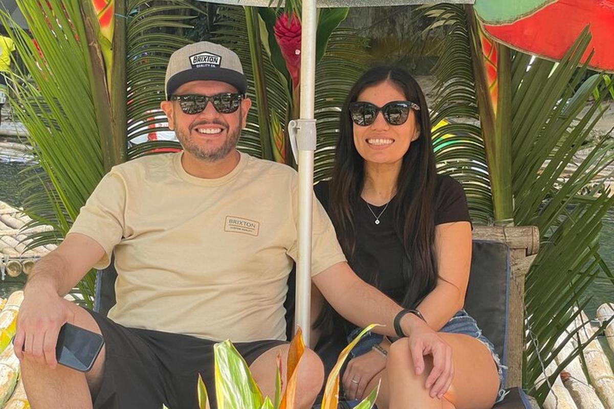 a man and a woman sitting on a chair under an umbrella
