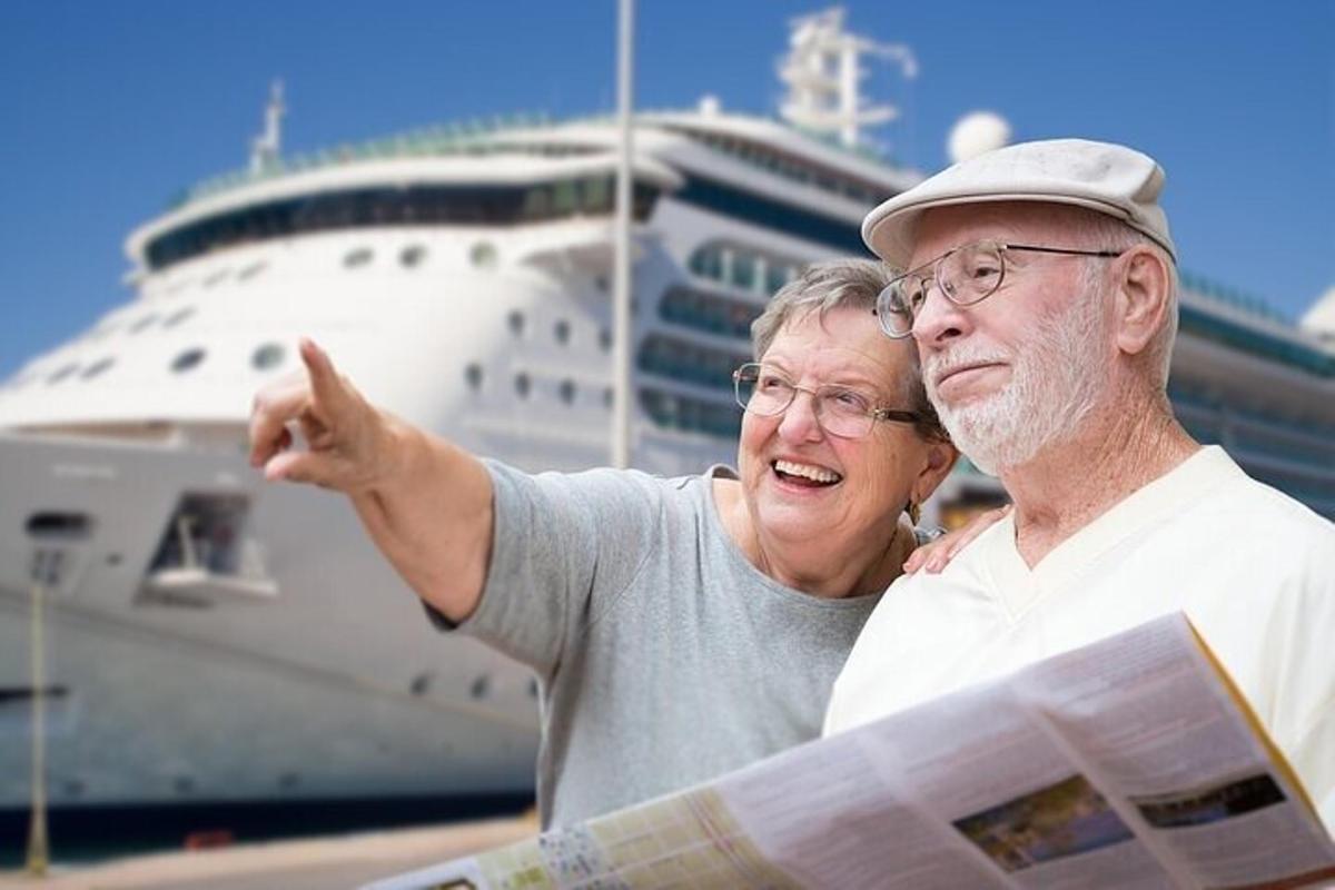 an older man and woman standing in front of a cruise ship