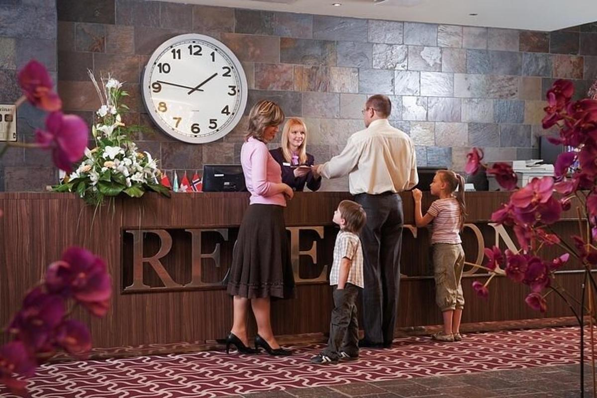 una famiglia in piedi alla reception con un orologio
