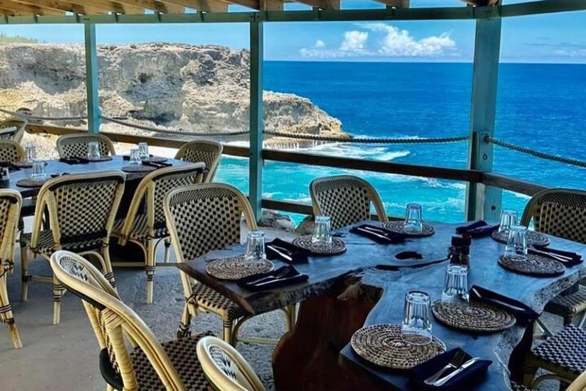 a restaurant with tables and chairs with a view of the ocean