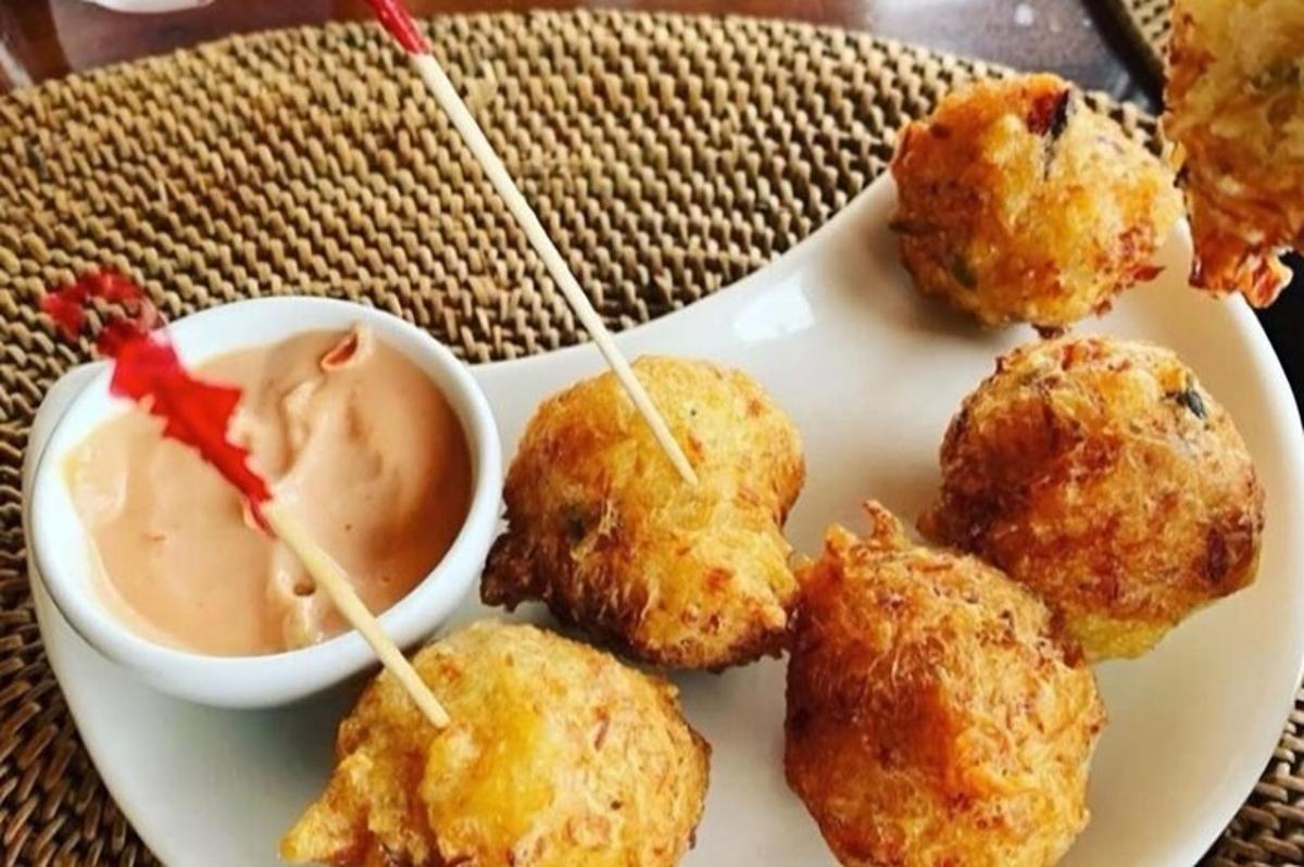 a plate of food with meatballs and a bowl of dipping sauce