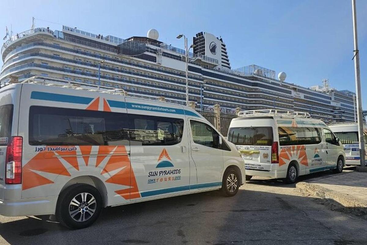 two vans parked in a parking lot in front of a cruise ship