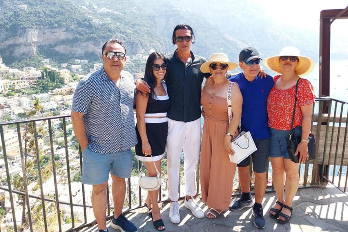 a group of people posing for a picture on a balcony