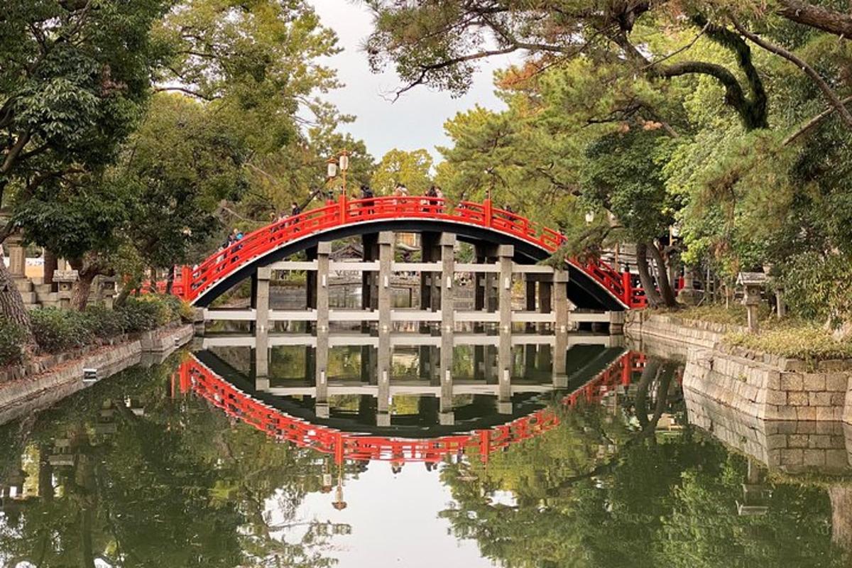 un puente rojo sobre un río en un parque