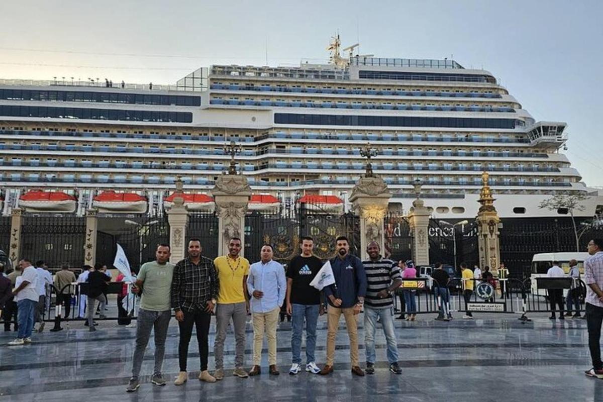 eine Gruppe von Menschen steht vor einem Kreuzfahrtschiff