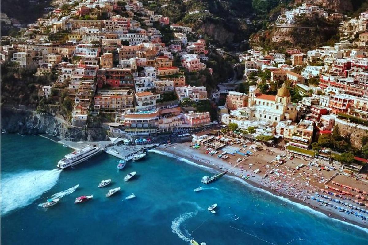 an aerial view of a beach with boats in the water