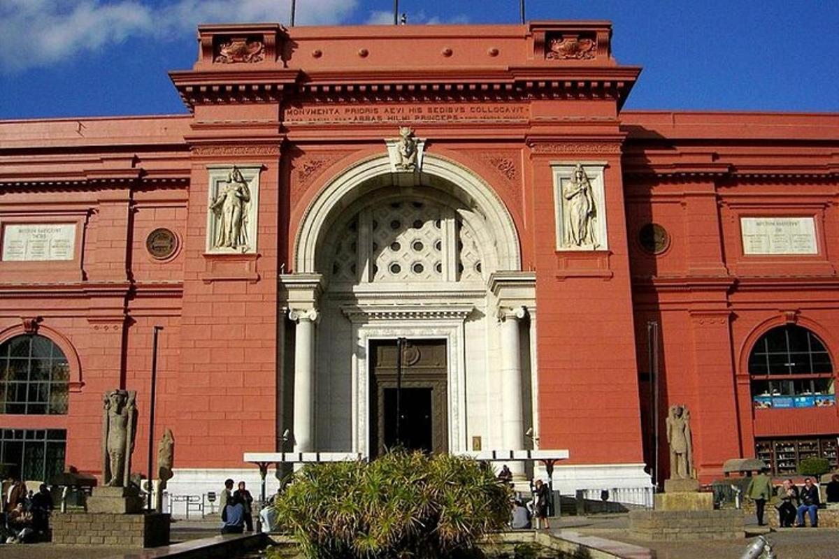 ein großes rotes Backsteingebäude mit Statuen davor