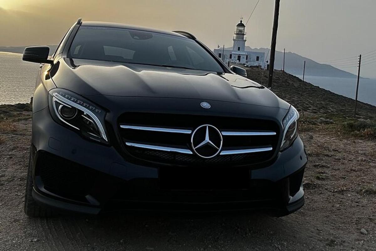 a mercedes benz car parked in front of a lighthouse