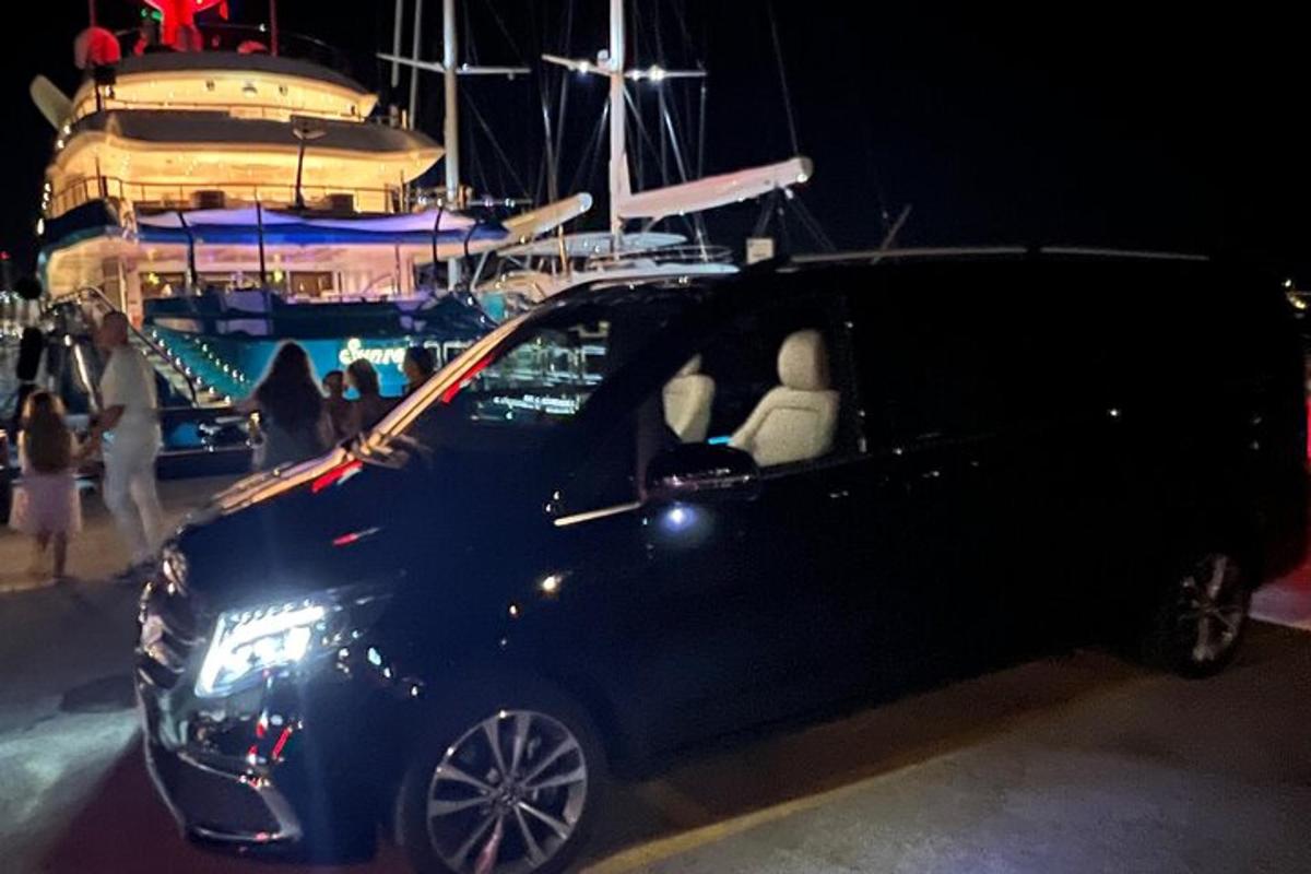 een kleine zwarte auto geparkeerd voor een boot