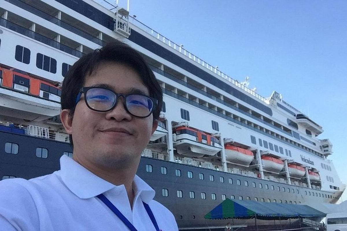 一名戴眼镜的男子站在游轮前