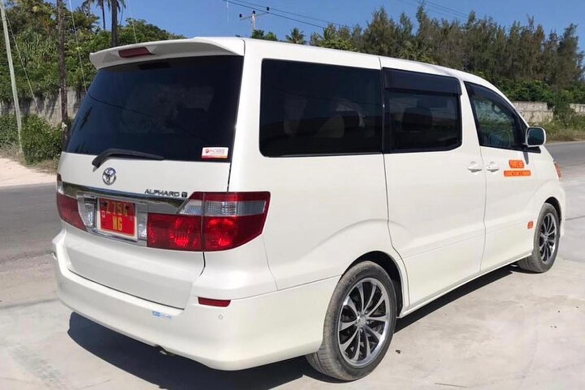 một chiếc xe tải nhỏ màu trắng đỗ trong bãi đậu xe