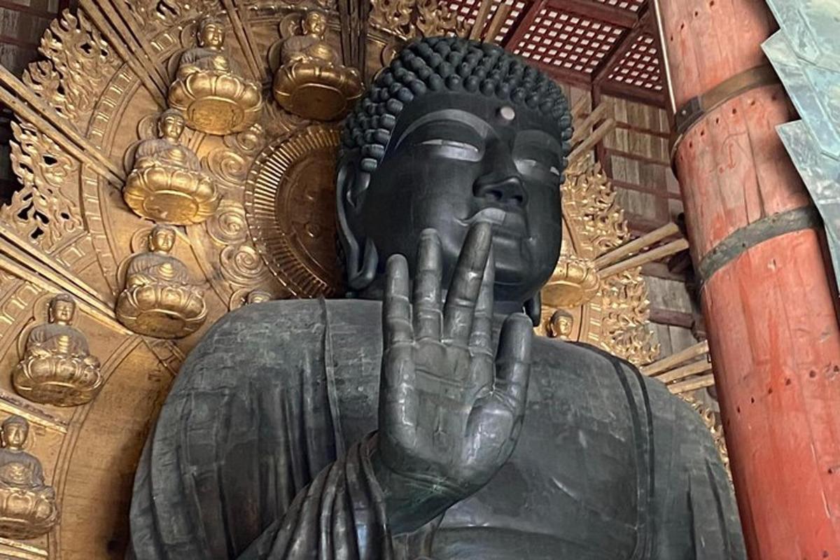 una statua davanti a un muro dorato