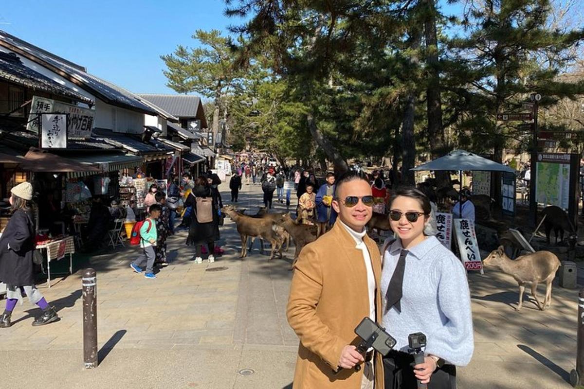 un uomo e una donna in piedi su una strada con una macchina fotografica