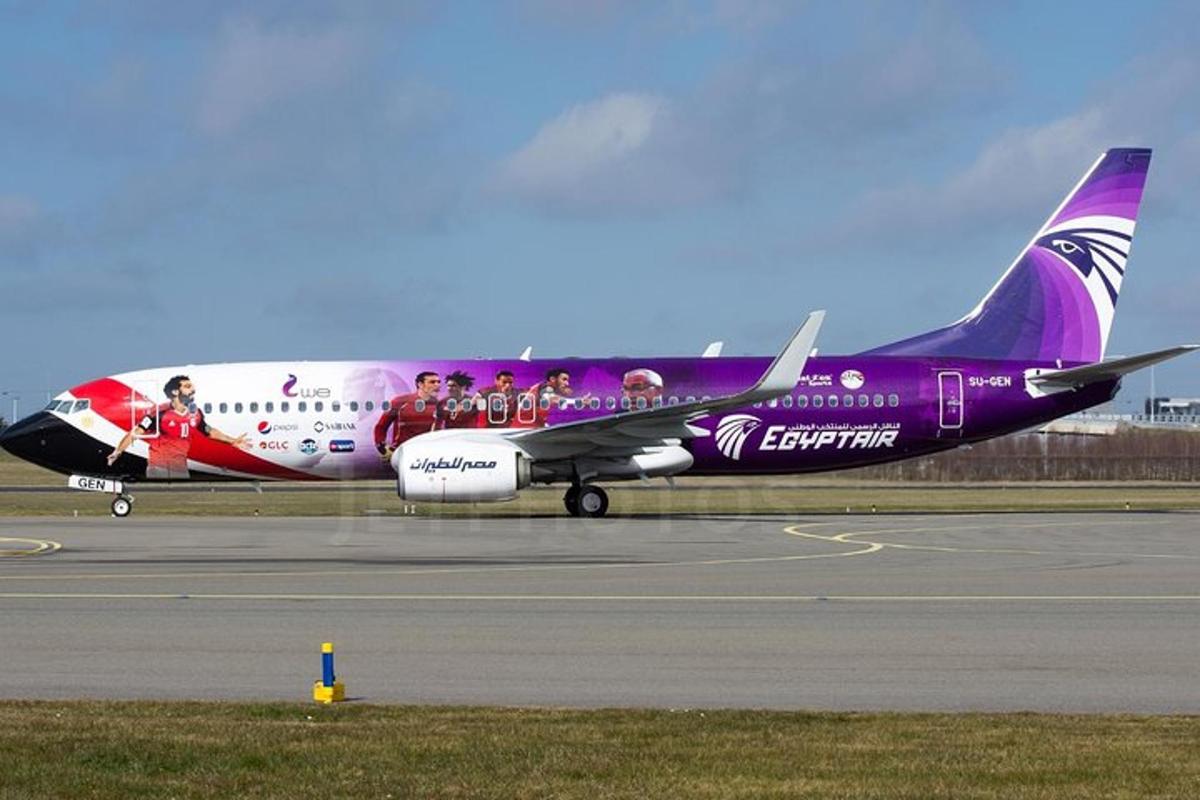 um avião roxo e branco está na pista