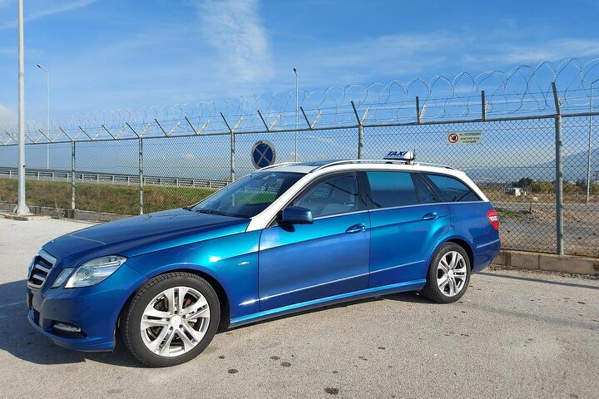 um carro azul estacionado em frente a uma cerca