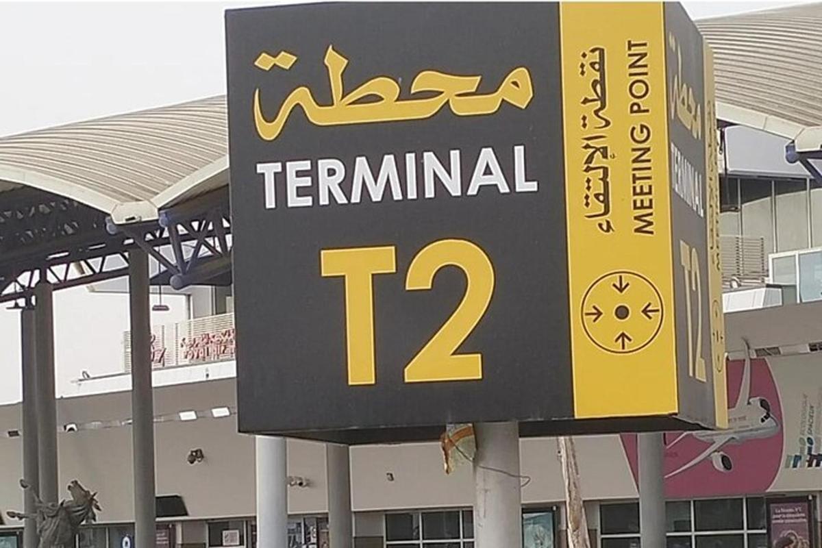 uma placa de terminal para uma placa de terminal em frente a um edifício