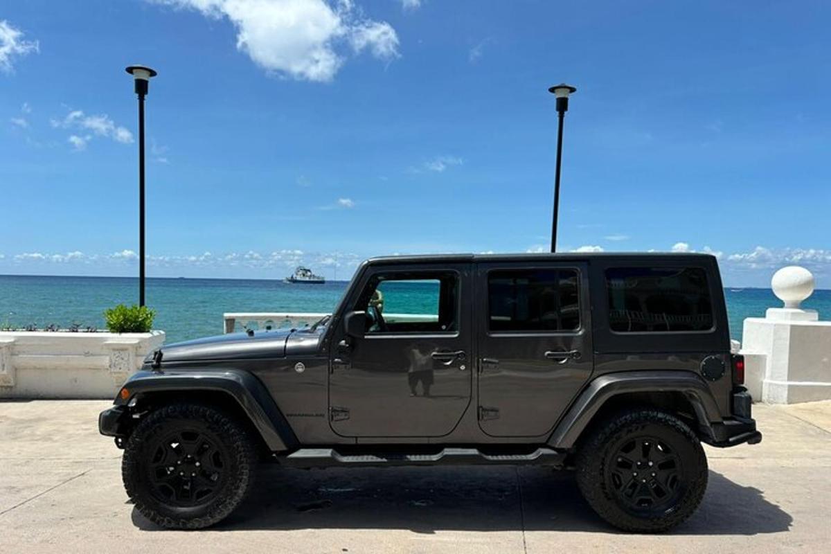 a gray jeep parked in front of the ocean