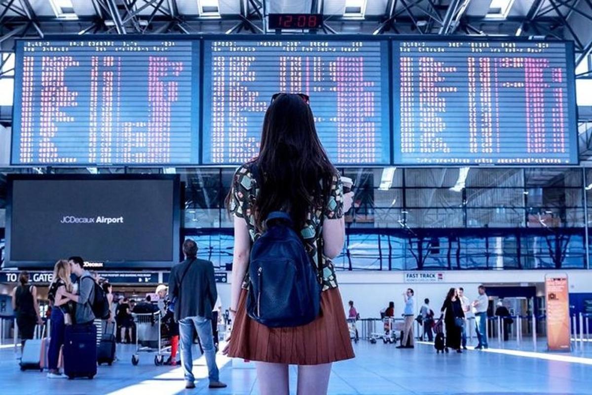 una dona amb una motxilla dempeus en un aeroport