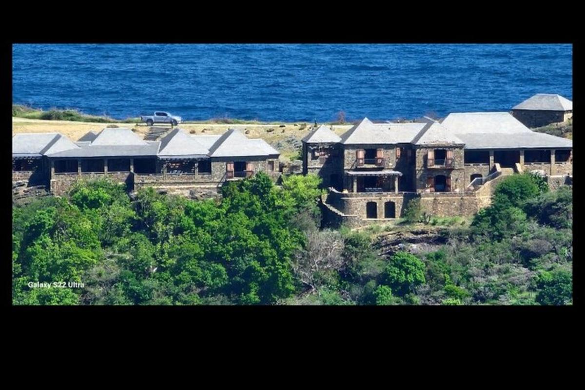 a large house on a hill next to the ocean