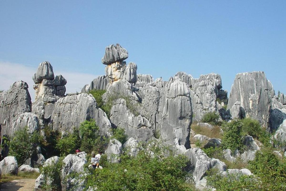 a rocky mountain with some people standing in front of it