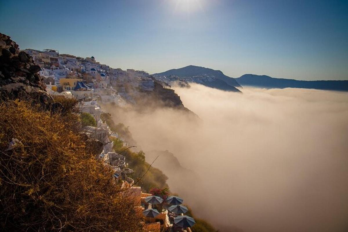 uma vista de uma montanha coberta de neblina com casas e edifícios