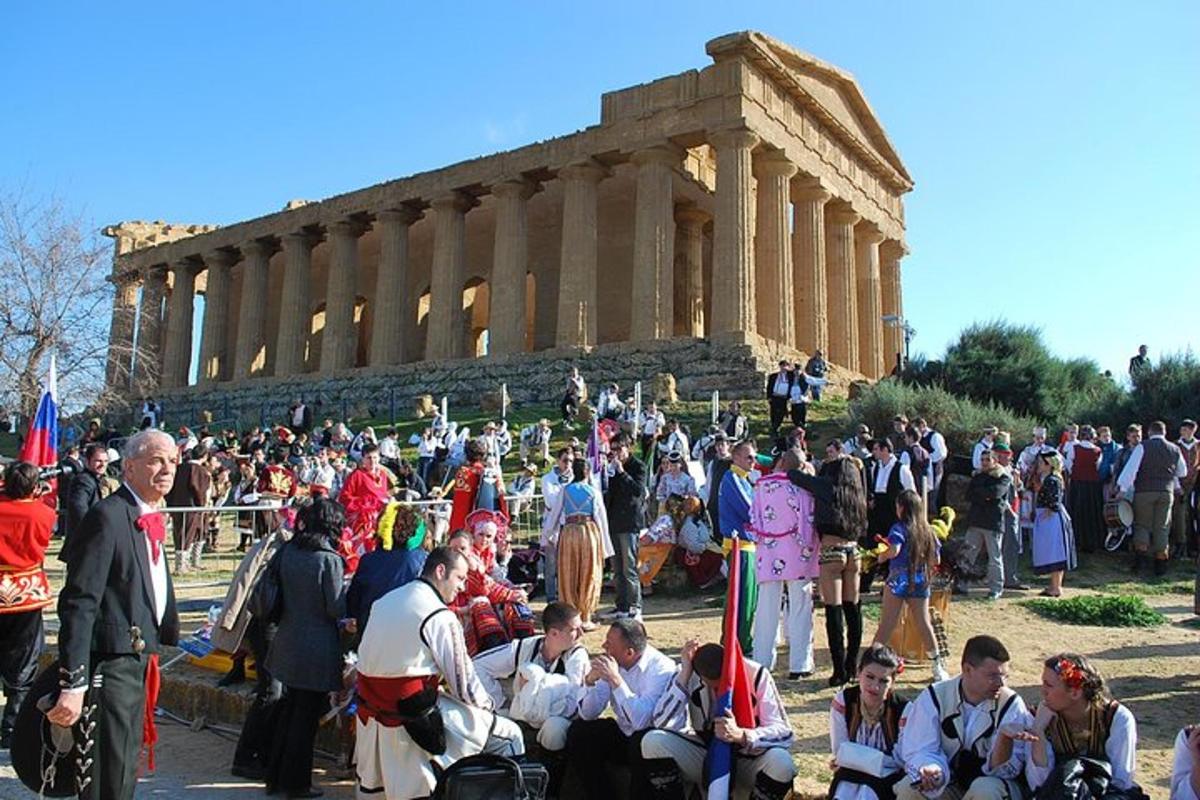 una multitud de personas de pie frente a un templo