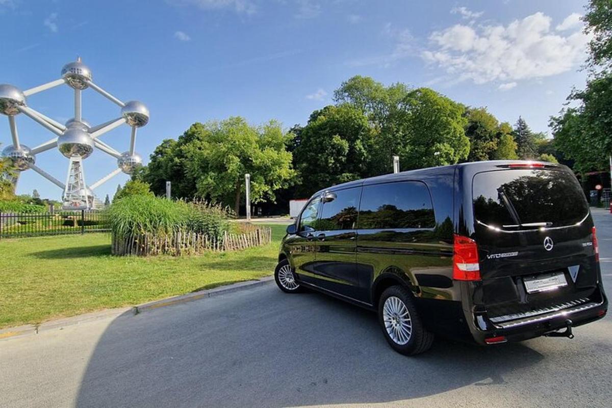 a black van parked in front of a roller coaster
