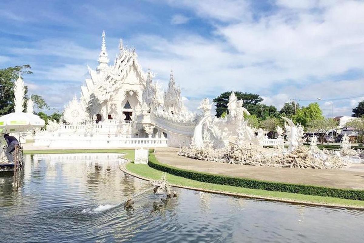 een witte tempel met een vijver en een brug