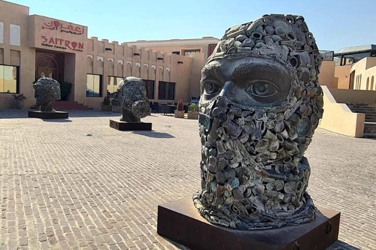 a statue of an owl on a sidewalk in front of a building