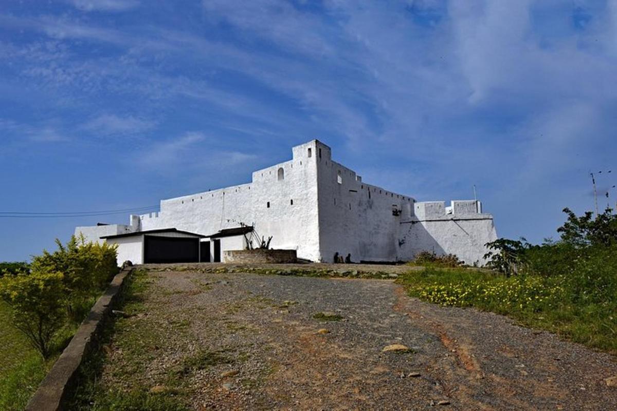 a white building sitting on top of a dirt road
