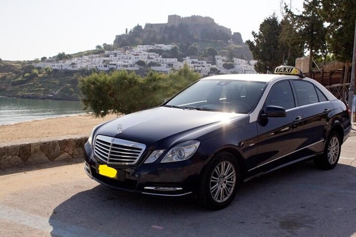 Un coche negro aparcado junto a una playa