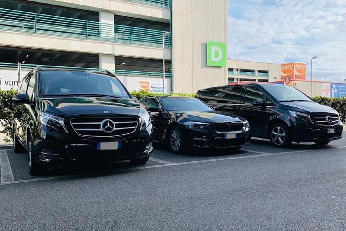 tři auta zaparkovaná na parkovišti před budovou