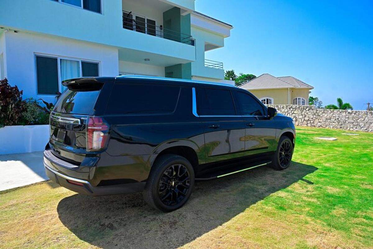 sebuah mobil SUV hitam diparkir di depan sebuah rumah