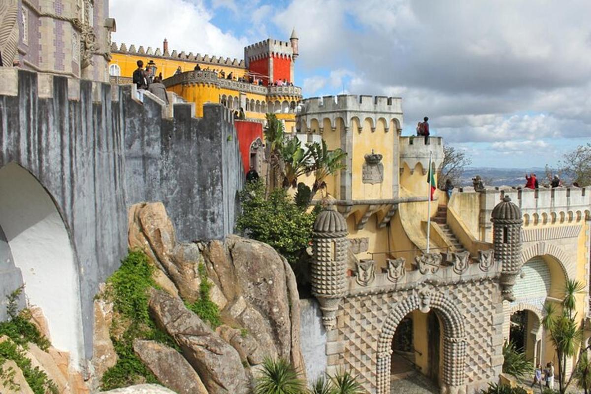 un castel pe un munte cu oameni pe un pod