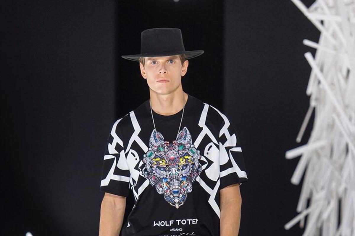 a young man wearing a hat and a black and white shirt