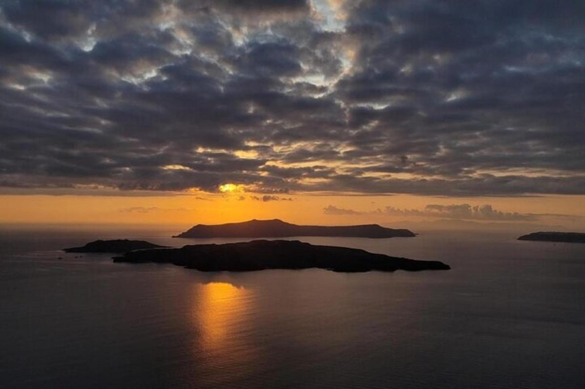 Una isla en el océano con una puesta de sol al fondo