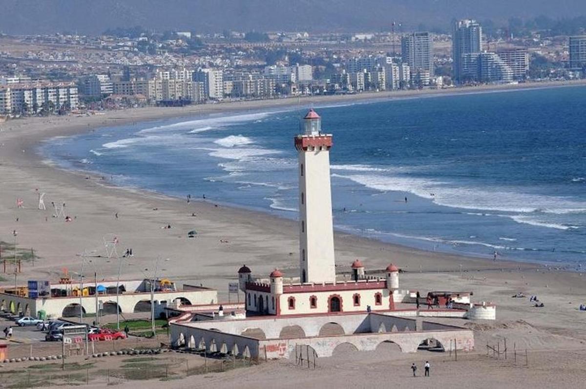 a lighthouse on a beach next to the ocean