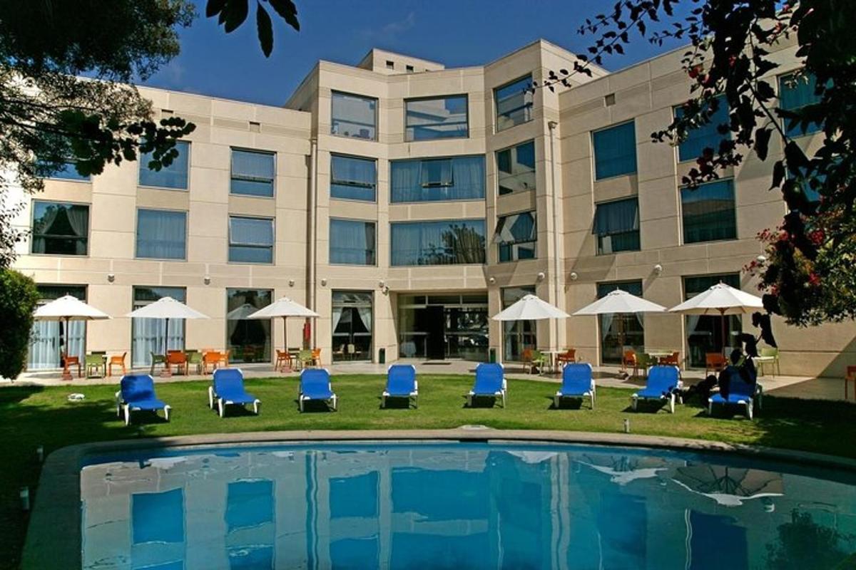 a hotel with chairs and a pool in front of a building
