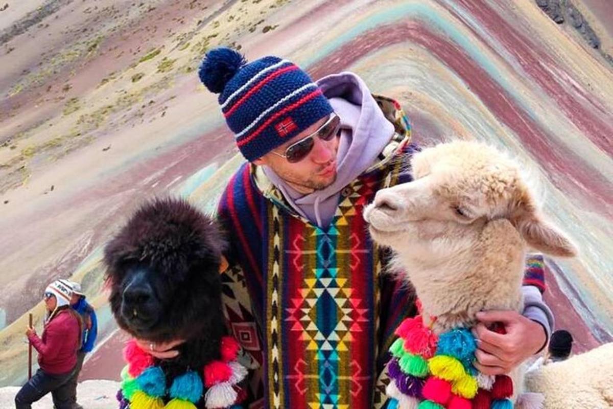 un uomo che tiene in braccio due pecore e un cane